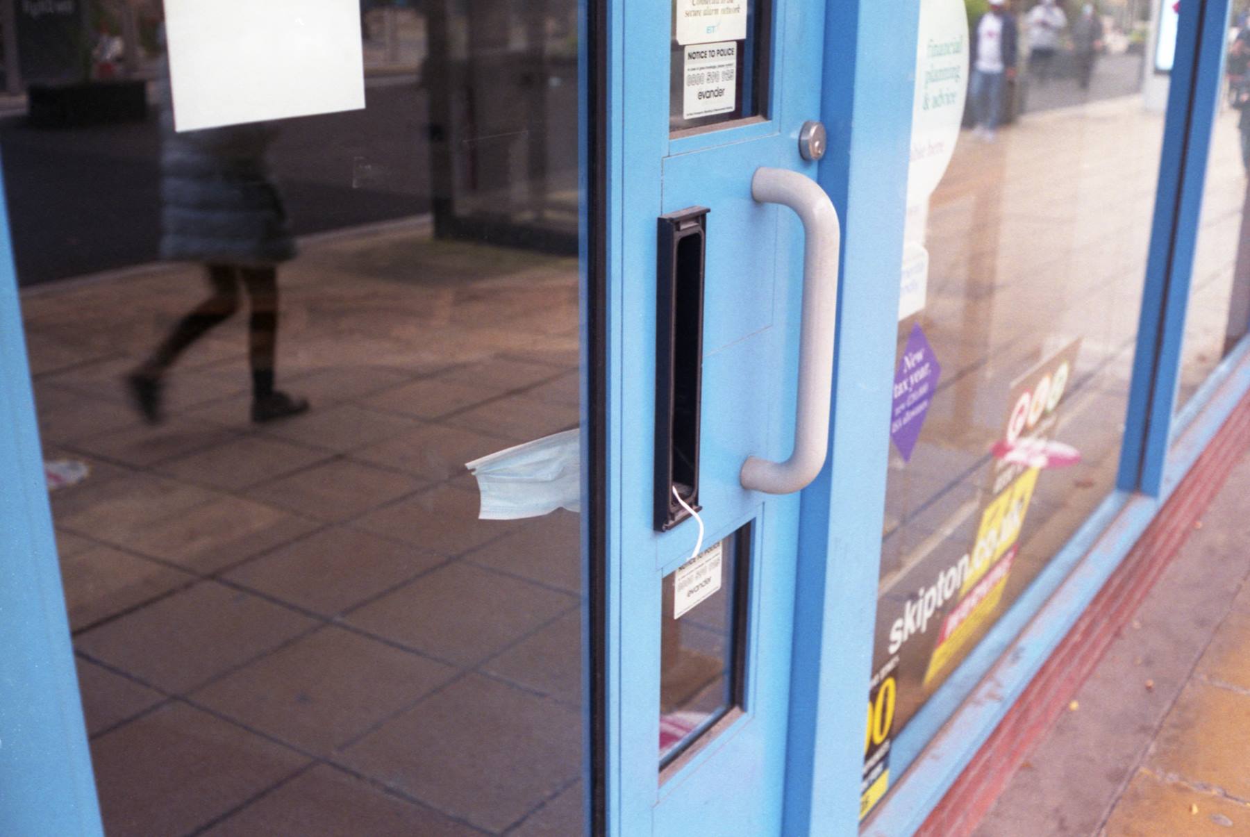 A surgical mask discarded in a letter box
