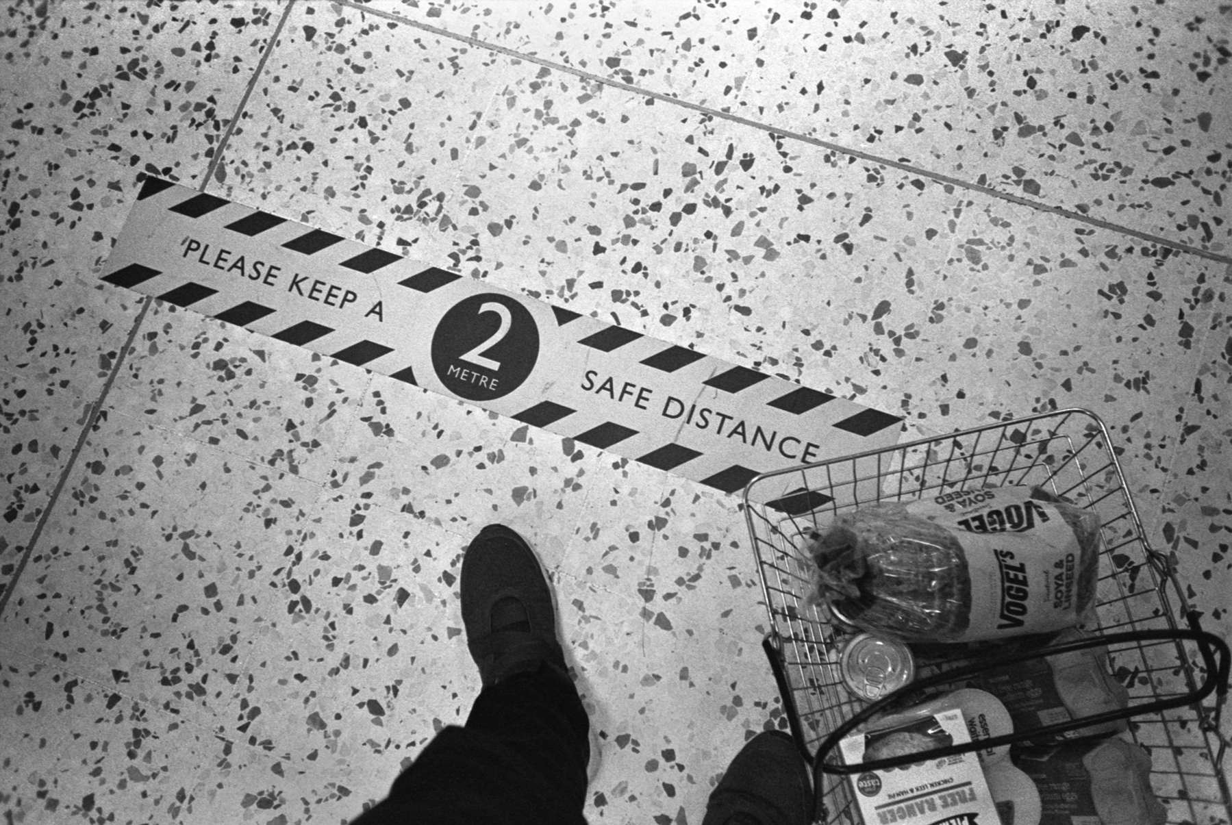 A notice on a supermarket floor to keep a 2 meter distance